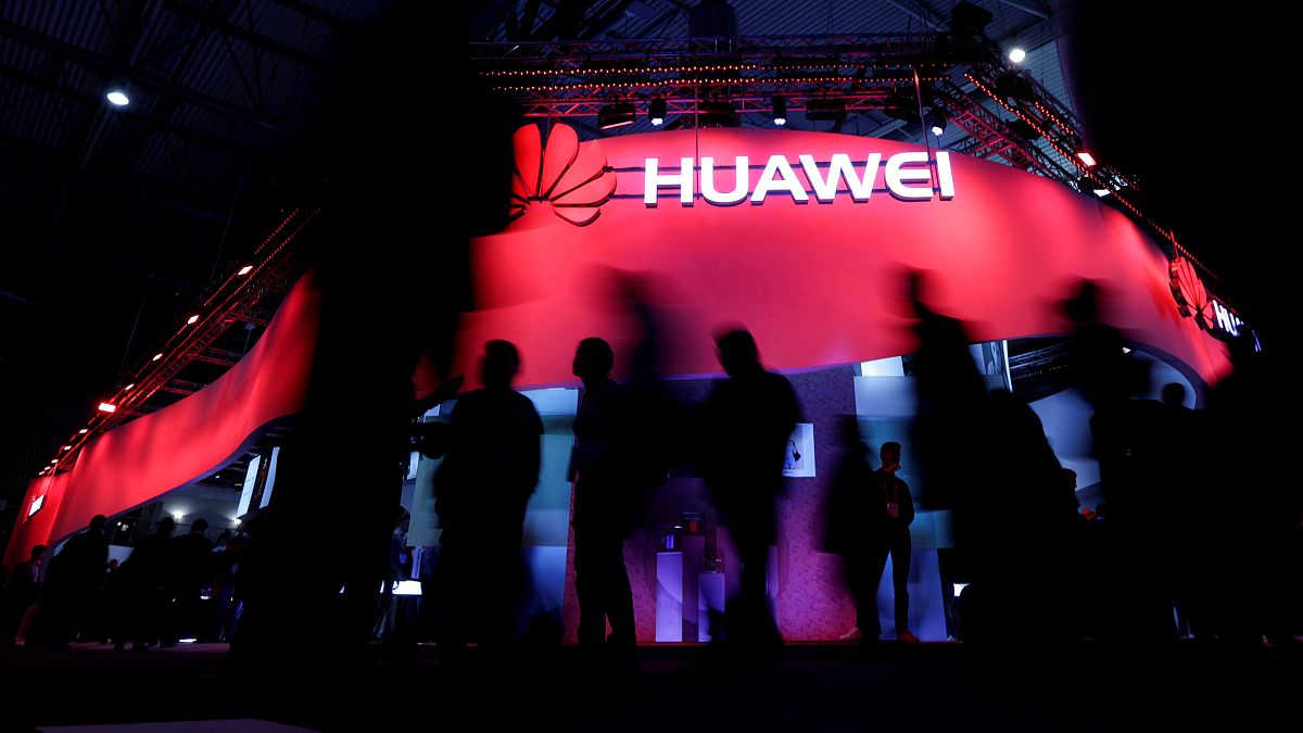 Image: Visitors walk past the Huawei booth at the Mobile World Congress in 