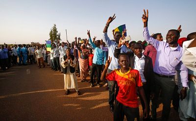 Sudanese people flash the victory gesture outside a prison in Omdurman on July 4, during a ceremony marking the release of 235 members of a faction of the Sudan Liberation Army, which has fought government forces in Darfur.