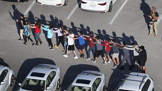 Image: People are brought out of the Marjory Stoneman Douglas High School a