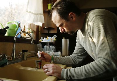 Jeremiah Underhill checks the pH level of the water coming out of his kitchen faucet at his home in Richfield, Pennsylvania on March 8, 2016.