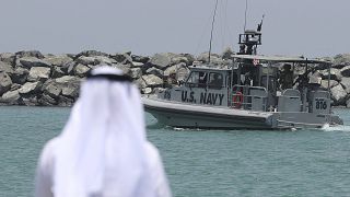 Image: A U.S. Navy patrol boat carrying journalists to see damaged oil tank