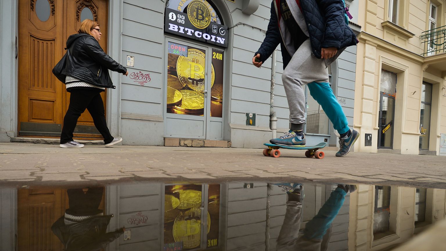 People pass in front of a Bitcoin exchange