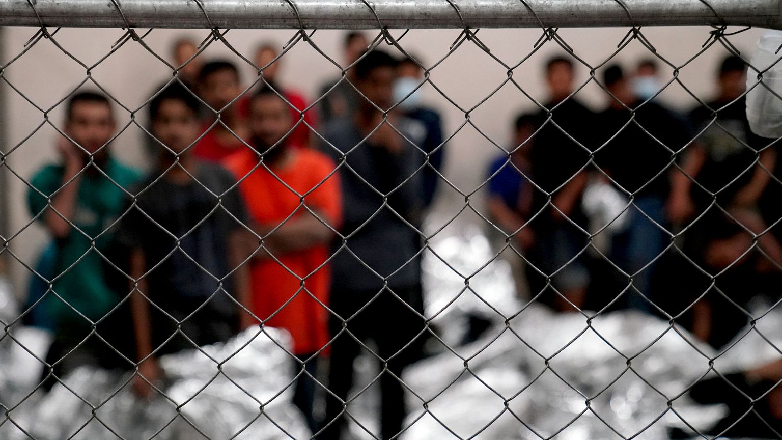 Image: Adult male detainees stand inside a holding area at the Border Patro