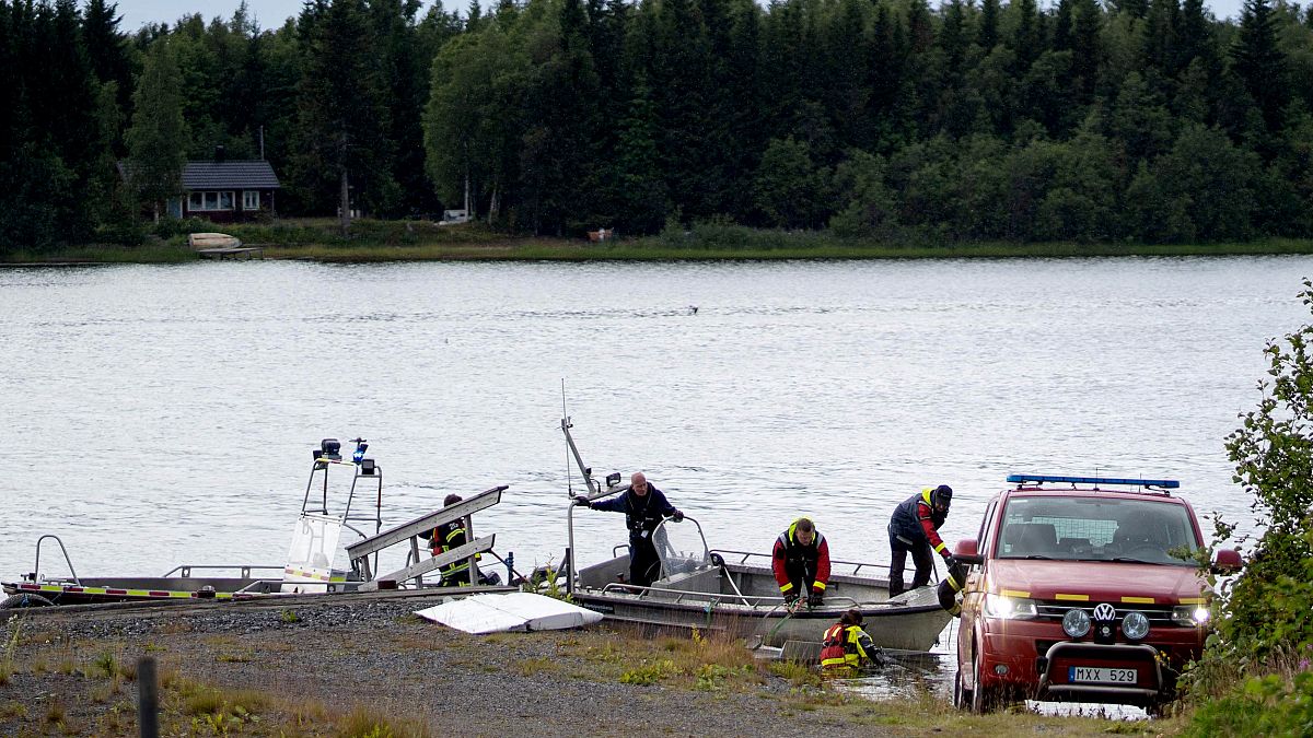 Image: An emergency services boat carries wreckage after a small airplane c