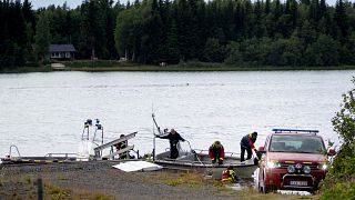 Image: An emergency services boat carries wreckage after a small airplane c