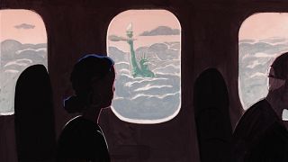 A woman gazes out an airplane window at the Statue of Liberty engulfed in c