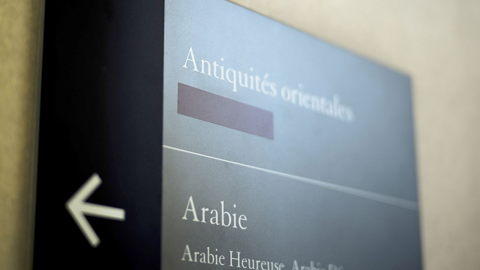 Image: A taped over sign is pictured at the Louvre Museum in Paris, France
