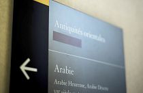 Image: A taped over sign is pictured at the Louvre Museum in Paris, France