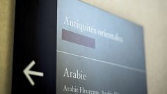 Image: A taped over sign is pictured at the Louvre Museum in Paris, France