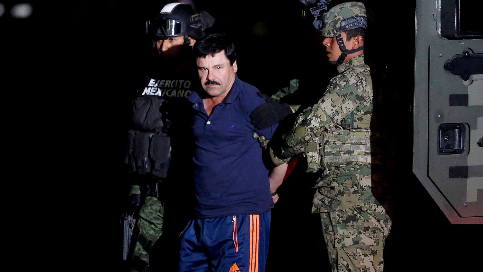 Image: Joaquin "El Chapo" Guzman is escorted by soldiers during a presentat