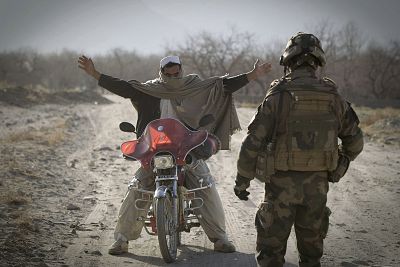 A soldier inspects an Afghan man on motorcycle near Tagab in Kapisa Province on Jan. 25, 2011.