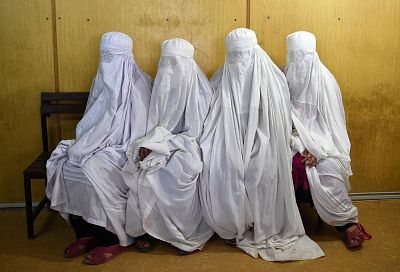 Afghan refugee women wait to scans their eyes at the UNHCR registration center in the Pakistani city of Peshawar on June 19, 2017.