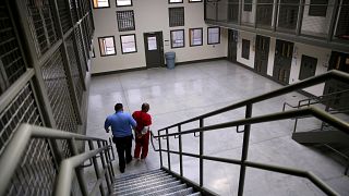 Image: A guard escorts an immigrant detainee from his segregation cell back