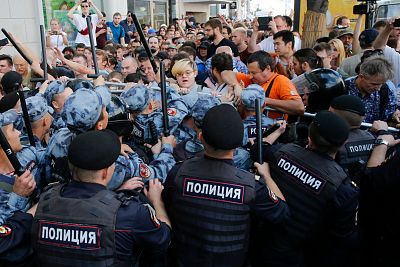 Protesters attempt to break through a police cordon during an unauthorized rally demanding independent and opposition candidates be allowed to run for office in local election in September, in Moscow on July 27, 2019.