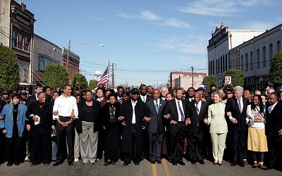 Barack Obama and Hillary Clinton march with a crowd to the Edmund Pettus Bride to commemorate the 1965 Bloody Sunday voting rights march in Selma, Alabama, on March 4, 2007.