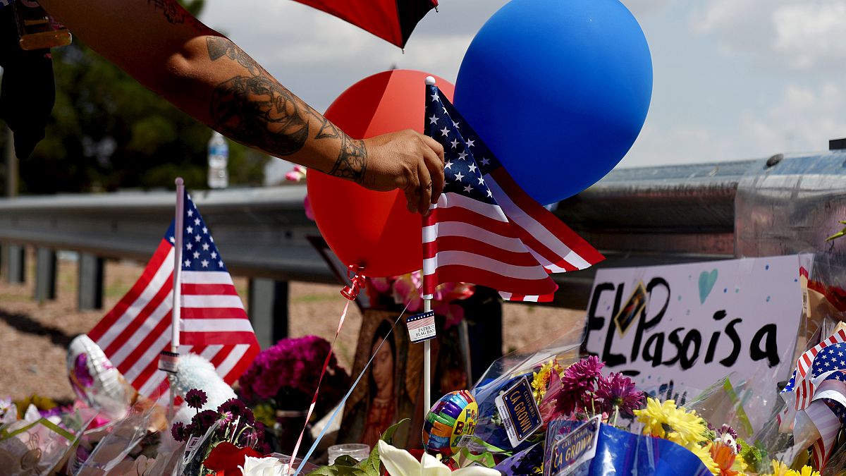 Image: A man places an American flag at a makeshift memorial near the site 