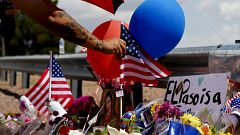 Image: A man places an American flag at a makeshift memorial near the site 