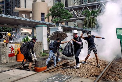 Protesters get hit with tear gas outside the Tin Shui Wai police station during a protest on Monday.