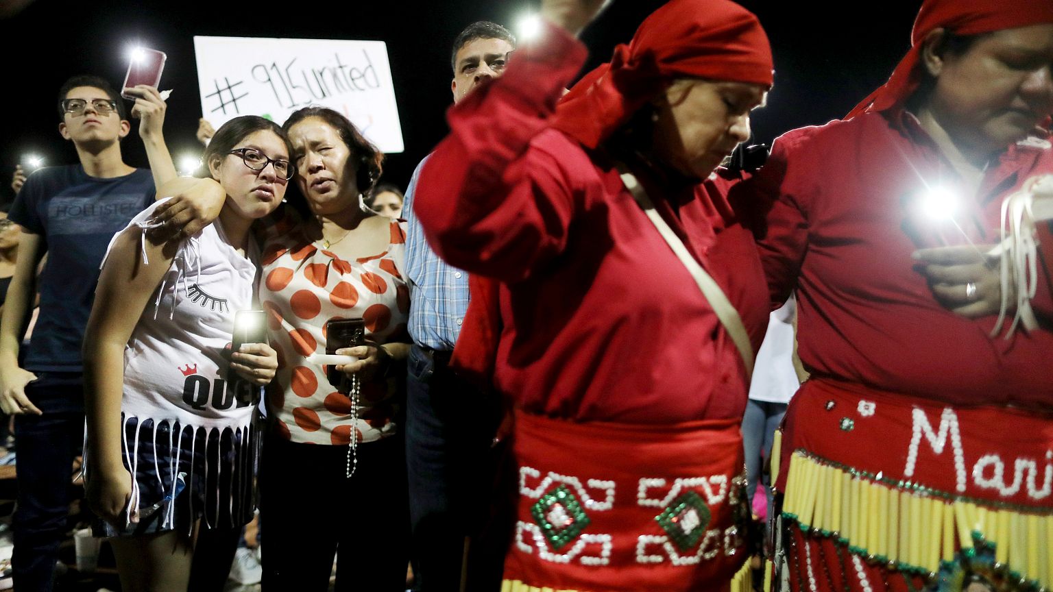 Image: People embrace at a vigil for victims of a mass shooting that left 2