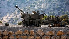 Image: Israeli soldiers sit inside a self-propelled artillery gun near the 