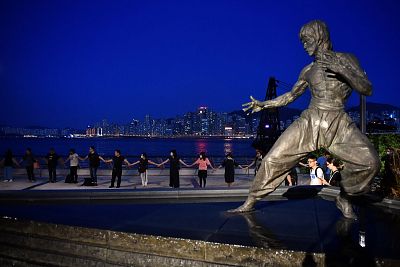 A statue of martial arts legend Bruce Lee, with protesters behind, in Victoria Harbor in Hong Kong, Aug. 23.