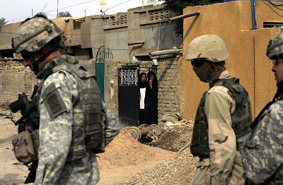 Iraqi women look at the U.S. soldiers and their Iraqi interpreter as they patrolled in eastern Baghdad on Oct. 2, 2006.