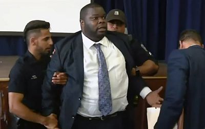 Willie Burton, a member of Detroit\'s Board of Police Commissioners, is arrested during a heated meeting where facial recognition technology was discussed.