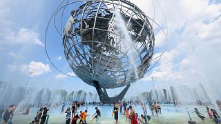 Image: People cool off at the Unisphere fountain at Flushing Meadow Corona