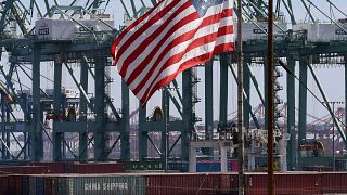 Image: The U.S. flag flies over Chinese shipping containers that were unloa