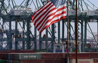The U.S. flag flies over Chinese shipping containers that were unloaded at the Port of Long Beach, in Los Angeles County.