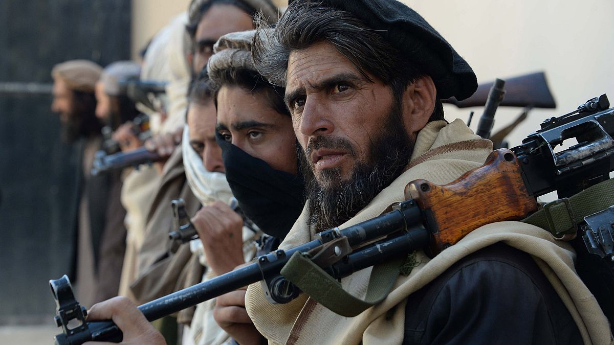 Image: Afghan alleged former Taliban fighters carry their weapons before ha