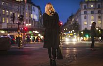 Rear view of woman walking on city street at night