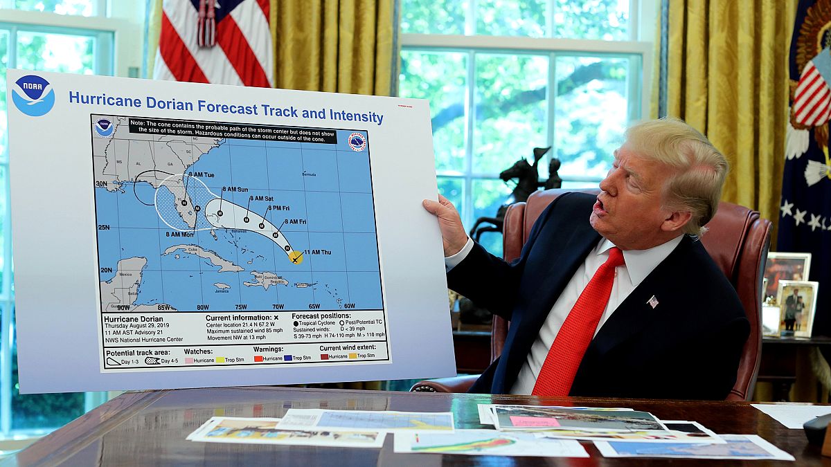 Image: UPresident Donald Trump holds an early projection map of Hurricane D