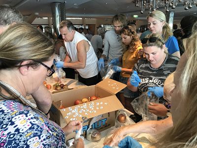 Guests of the Celebrity Equinox help to pack meals to be delivered to survivors of Hurricane Dorian in Freeport, Bahamas.