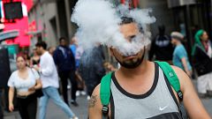 Image: A man uses a vape as he walks on Broadway in New York City