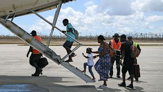 Image: Abaco residents are evacuated from the island at the airport in the 