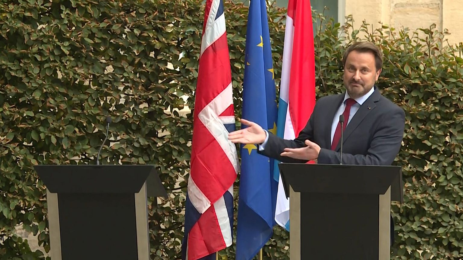Image: Luxembourg's Prime Minister Xavier Bettel gestures to an empty podiu