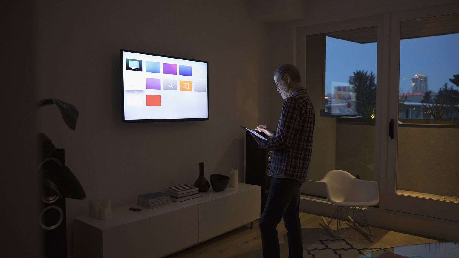 Image: A man using smart TV apps via a digital tablet.