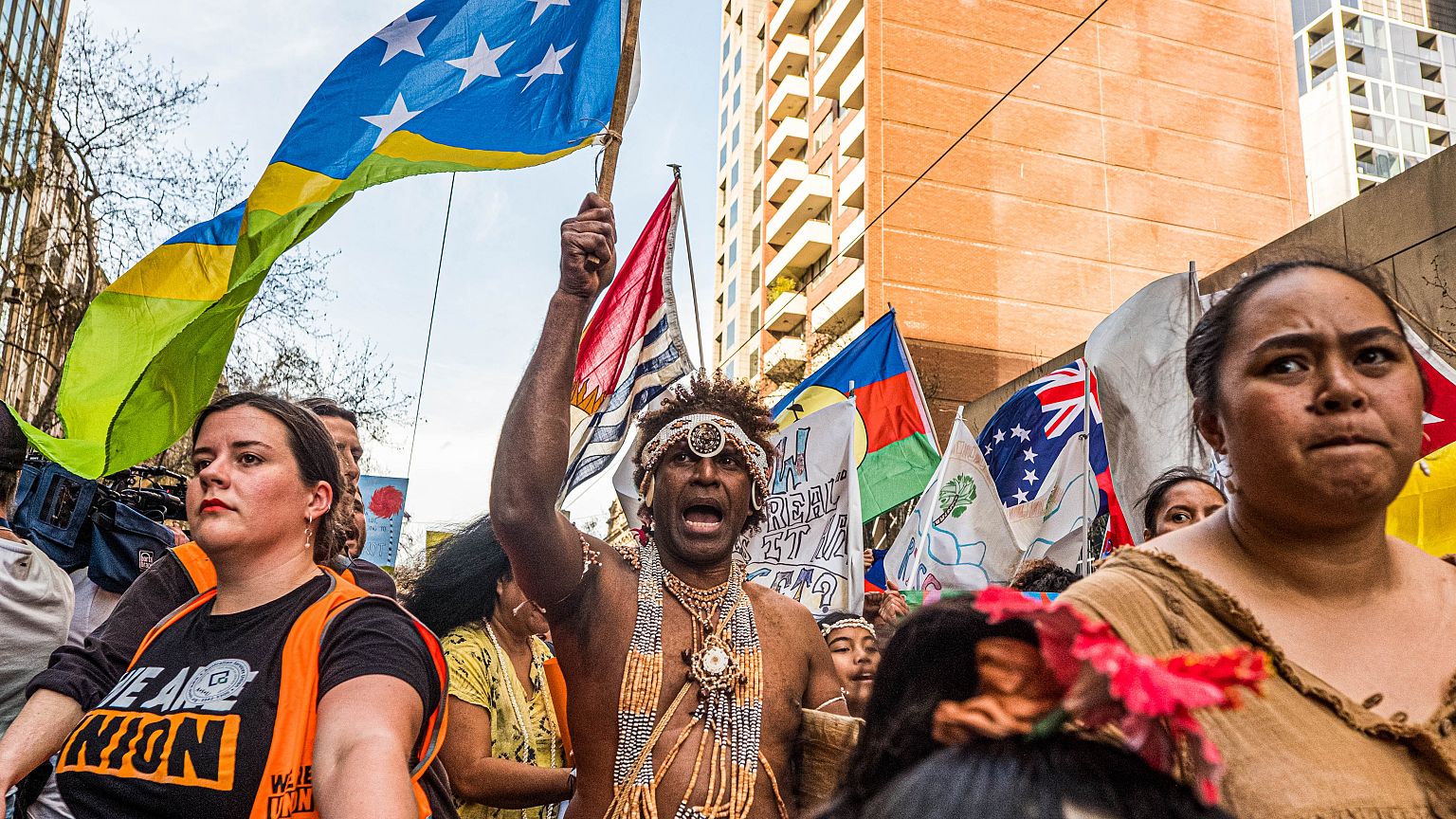 Image: A man wearing the traditional dress of the Solomon Islands march on 