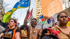 Image: A man wearing the traditional dress of the Solomon Islands march on 