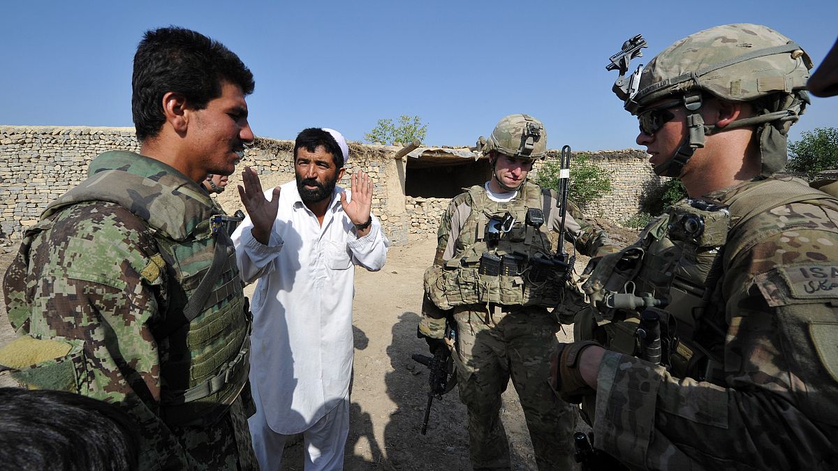 Image: An Afghan soldier (L) serves an interpre