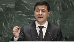 Image: President of Ukraine Volodymyr Zelensky holds up a bullet as he addr
