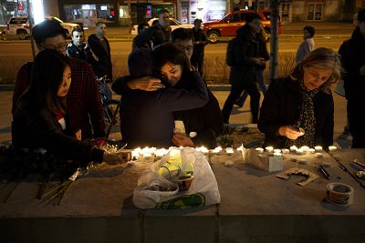 People embrace as they lay candles and leave messages at a memorial for victims of a crash on Yonge St. at Finch Ave., after a van plowed into pedestrians on April 23, 2018 in Toronto, Canada.