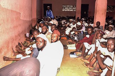 Some of the male students of "different nationalities" sit on the floor in chains outside a torture chamber on Sept. 26, 2019 in the Rigasa area of Kaduna in northern Nigeria after being rescued by police.