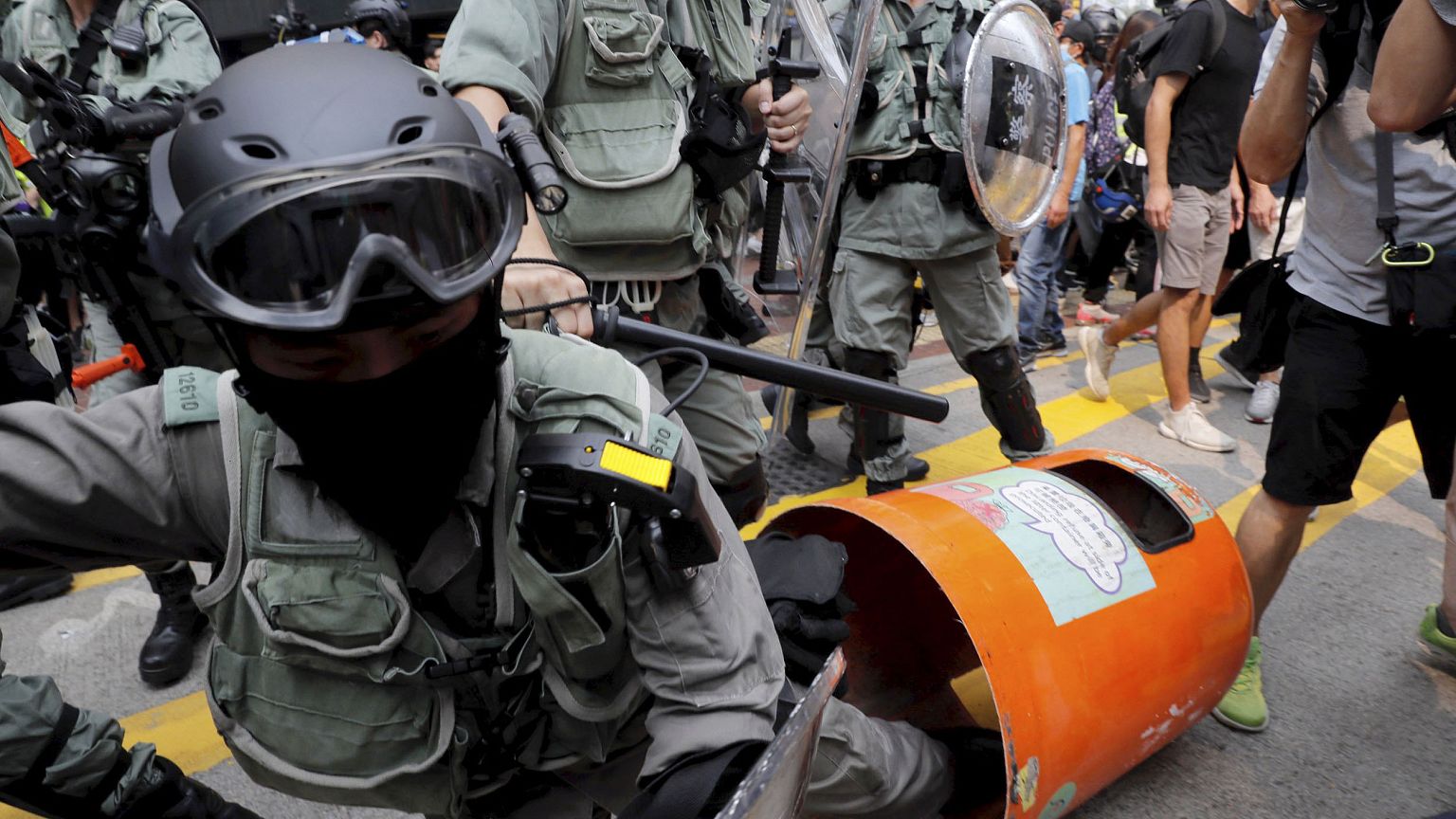 Image: A Hong Kong police officer steps into a trash bin by accident as the