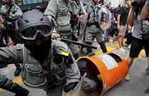 Image: A Hong Kong police officer steps into a trash bin by accident as the