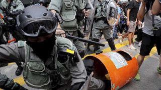 Image: A Hong Kong police officer steps into a trash bin by accident as the