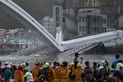 Rescue personnel stand near the site of a collapsed bridge at Nanfangao fish harbor in Suao township on Oct. 1, 2019.