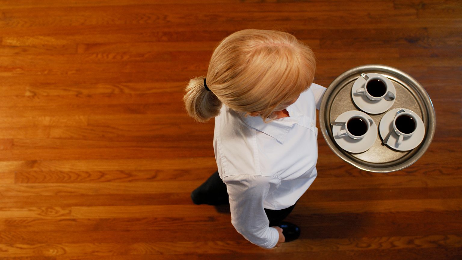 Woman carrying a tray of coffee cups, overhead view