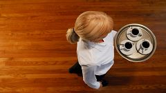 Woman carrying a tray of coffee cups, overhead view